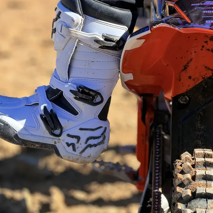 Close-up of Kapakū's boot on the peg of his KTM